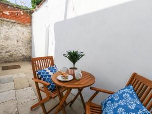 a table and chairs on a patio with a cup of coffee at The Watch House in Weymouth