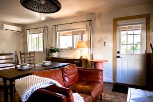 a living room with a leather couch and a table at Designer King Studio Private Curated Cottage in Cottonwood