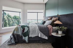a bedroom with a bed and a large window at Byron Retreat in Coopers Shoot
