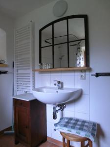 a bathroom with a sink and a mirror and a stool at Ferienwohnung mit Charme in Dresden Pillnitz in Dresden