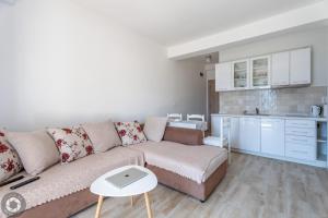 a living room with a couch and a kitchen at Bonaca Apartments in Kotor