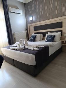 a bedroom with a large bed with blue and white pillows at Çiçek Hotel in Ankara