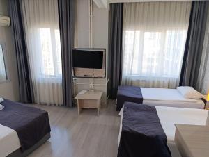 a hotel room with two beds and a flat screen tv at Çiçek Hotel in Ankara +24 photos