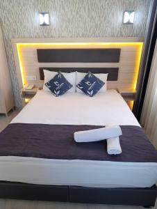 a bedroom with a large white bed with blue pillows at Çiçek Hotel in Ankara