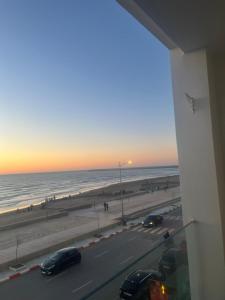 a view of the beach at sunset from a hotel room at Perle de LAtlantique in Kenitra