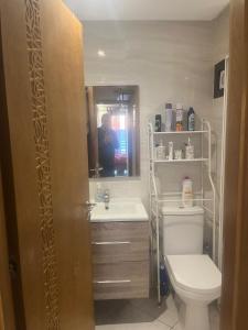 a bathroom with a toilet and a sink and a mirror at Perle de LAtlantique in Kenitra