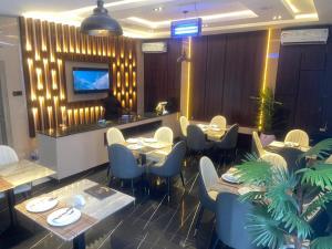 a restaurant with tables and chairs and a television at Classy Castle Hotel and Suite in Orho Agbarho