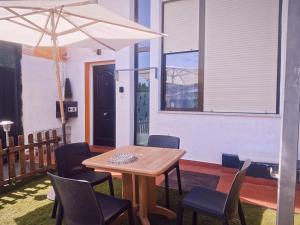 a wooden table with chairs and an umbrella at Apartamento Premium Relax C in Bárcena de Cicero