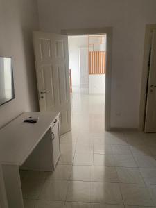 a white kitchen with a white counter and a hallway at Dietro La Torre in Lizzano