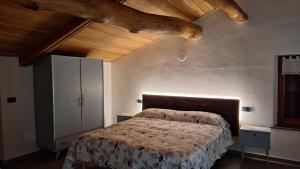 ein Schlafzimmer mit einem Bett und einer Holzdecke in der Unterkunft I Sitoù in Ostana