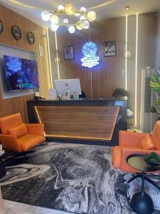 a lobby with a reception desk and orange chairs at Classy Castle Hotel and Suite in Orho Agbarho