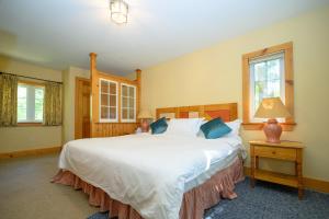 a child sitting on a large bed in a bedroom at 148 Divot Simcoe Cottage private Beach, Kayak in Georgina +13 photos