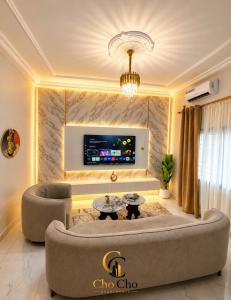 a living room with a couch and a tv at ChoCho Apartments in Limbe