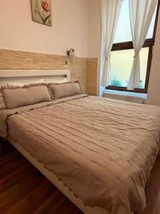 duże łóżko w sypialni z oknem w obiekcie Raphaela Residence w Bystrzycy