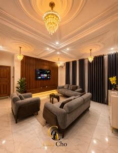 a living room with couches and a chandelier at ChoCho Apartments in Limbe