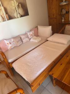 two beds in a room with a couch at Gradakia Cottages 1 in Argostoli