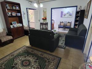 a living room with two couches and a rug at Pousada das Hortensias in Conservatória