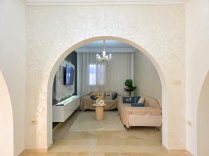 an archway in a living room with a couch and a tv at Villa Safiya in Djerba