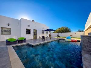 a swimming pool in the backyard of a house at Villa Safiya in Djerba