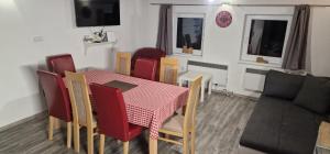 a dining room with a table and chairs and a couch at Chalupa Pohoda Demänová in Liptovský Mikuláš – Demänová