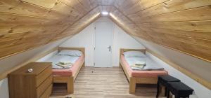 two beds in a small room with a wooden ceiling at Chalupa Pohoda Demänová in Liptovský Mikuláš – Demänová +33 photos