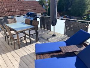 a patio with a table and chairs on a deck at Ferienwohnung Unterallgäu in Markt Rettenbach