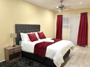 a bedroom with a large bed with red pillows at 35 Quanza in East London