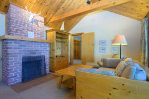 a living room with a brick fireplace and a couch at 148 Divot Simcoe Cottage private Beach, Kayak in Georgina