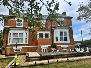 a house with a statue in front of it at Group Accommodation - Rushden A6 Manor House - Private Gated -Sleeps 15 - Secure Parking in Rushden