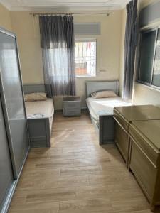 a room with two beds and a mirror at Jad Moon Stay in Fnidek +4 photos
