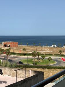 a view of a road and the ocean from a balcony at Jad Moon Stay in Fnidek