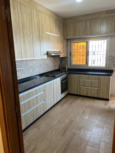 a kitchen with wooden cabinets and a stove top oven at Jad Moon Stay in Fnidek