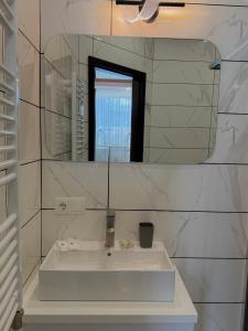 a white bathroom with a sink and a mirror at Старий Дуб in Mizhhirya