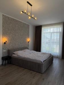a bedroom with a large bed and a chandelier at Старий Дуб in Mizhhirya