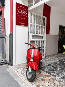a red scooter parked in front of a building at Il vecchio Fauno in Pompei +76 photos