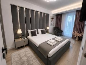 a bedroom with a large bed with two pillows on it at INFINITY Sea View Luxury SUITE in Mamaia Sat/Năvodari