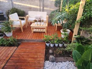 a patio with chairs and potted plants on a wooden deck at Casa Runa in Quillota