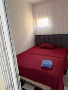 a bedroom with a red bed with a blue towel on it at melvina LUX in Pančevo +3 photos