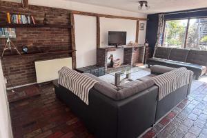 a living room with a couch and a fireplace at Sleeps 5 with in picturesque Chiddingly in Lewes