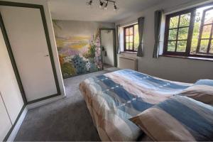 a bedroom with a bed and a painting on the wall at Sleeps 5 with in picturesque Chiddingly in Lewes