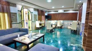 a lobby with a blue floor with a table and chairs at Hôtel Résidence le Berger in Nouakchott