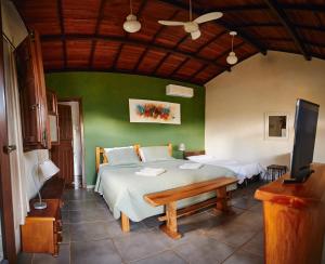 a bedroom with a bed and a flat screen tv at Pousada Capão da Coruja in Santa Bárbara