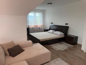 a living room with a bed and a couch at Apartmani JELIČIĆ in Zaovine