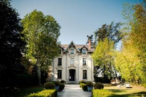 a large white house with a driveway at La Villa Kara in Romans-sur-Isère