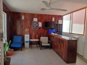 a room with a bar and chairs and a tv at Hotel Condesa Americana Acapulco in Acapulco