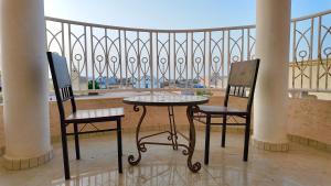 two chairs and a table on a balcony with a view at Hôtel Résidence le Berger in Nouakchott