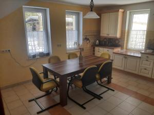 a kitchen with a wooden table and chairs at Ferienwohnung Lilie in Pegau