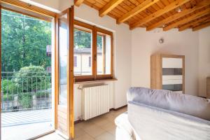 a living room with a couch and a window at Mirafiume - Lugano Lake in Valsolda