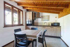 a kitchen and dining room with a wooden table and chairs at Mirafiume - Lugano Lake in Valsolda