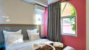 a hotel room with a bed and a window at Hôtel Résidence le Berger in Nouakchott +51 photos